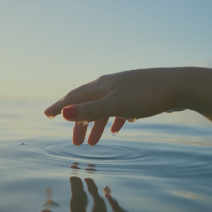 Hand über dem Wasser als Sinnbild für Vertrauen in die Therapie